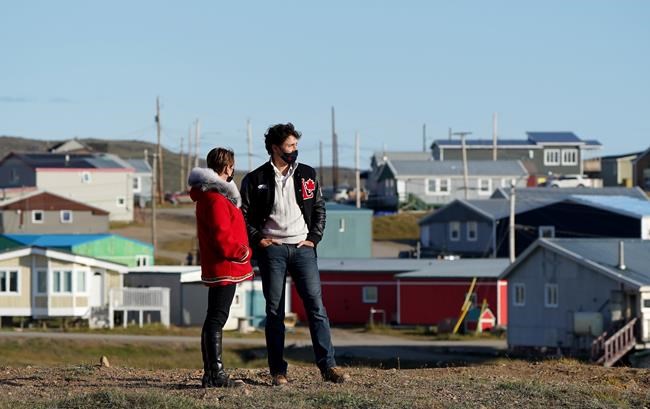Liberal Leader Justin Trudeau and Liberal candidate Pat Angnakak look on during a campaign stop in Iqaluit, Monday, Aug. 30, 2021. A new poll suggests Justin Trudeau's efforts to create wedge issues over private health care and his Liberal government's handling of the COVID-19 pandemic may have backfired. THE CANADIAN PRESS/Nathan Denette
