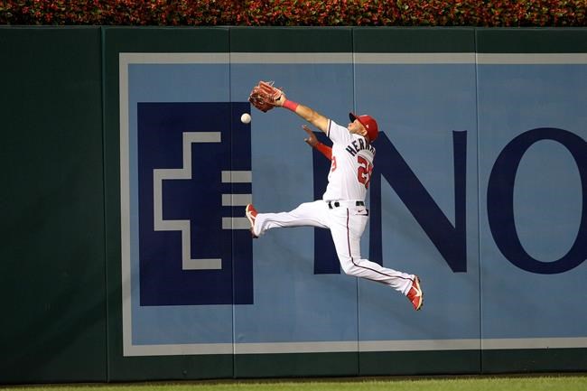 Washington Nationals left fielder Yadiel Hernandez can't get a ball that went for a triple by Philadelphia Phillies' Ronald Torreyes that scored three runs during the third inning of a baseball game on Monday, Aug. 30, 2021, in Washington. (AP Photo/Nick Wass)