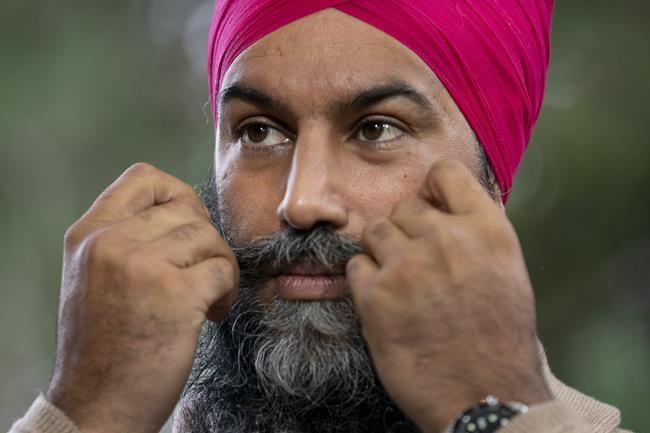 New Democratic leader Jagmeet Singh adjusts his moustache as he stands at the microphone during a campaign stop, Tuesday, August 31, 2021 in Coquitlam. THE CANADIAN PRESS/Adrian Wyld