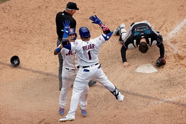 New York Mets' Javier Baez celebrates with Jonathan Villar after scoring the game winning run past Miami Marlins catcher Alex Jackson during the ninth inning of the first game of a baseball doubleheader that started April 11 and was suspended because of rain, Tuesday, Aug. 31, 2021, in New York. The Mets won 6-5. (AP Photo/Adam Hunger)