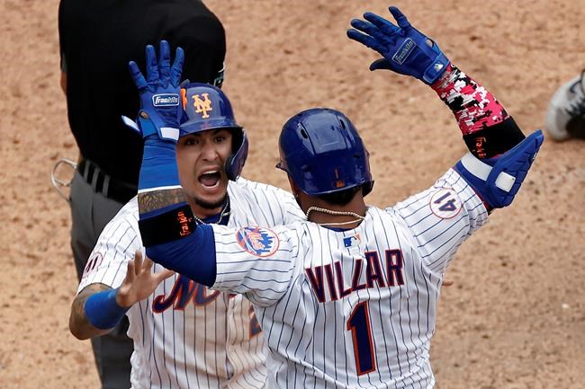New York Mets' Javier Baez celebrates with Jonathan Villar after scoring the game winning run against the Miami Marlins during the ninth inning of the first game of a baseball doubleheader that started April 11 and was suspended because of rain, Tuesday, Aug. 31, 2021, in New York. The Mets won 6-5. (AP Photo/Adam Hunger)