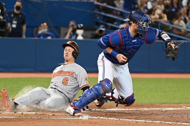Baltimore Orioles' Ryan Mountcastle (6) slides safely into home ahead of a tag by Toronto Blue Jays' catcher Danny Jansen in the sixth inning of an American League baseball game in Toronto on Tuesday, Aug. 31, 2021. THE CANADIAN PRESS/Jon Blacker
