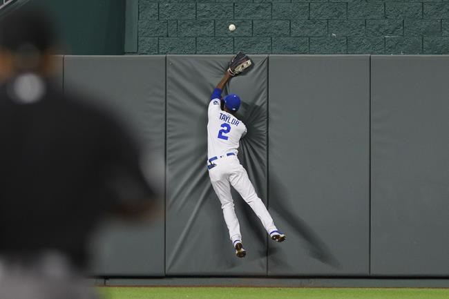 Kansas City Royals center fielder Michael A. Taylor can't catch a home run by Cleveland Indians' Amed Rosario during the seventh inning of a baseball game Tuesday, Aug. 31, 2021, in Kansas City, Mo. (AP Photo/Reed Hoffmann)