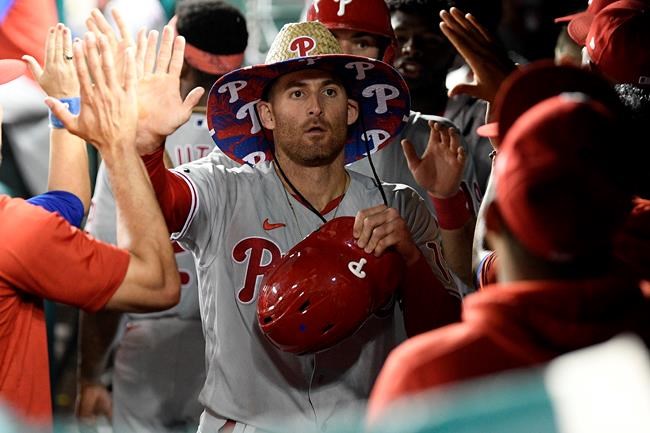 Philadelphia Phillies' Brad Miller is congratulated in the dugout for his two-run home run against the Washington Nationals during the ninth inning of a baseball game Tuesday, Aug. 31, 2021, in Washington. The Phillies won 12-6. (AP Photo/Nick Wass)