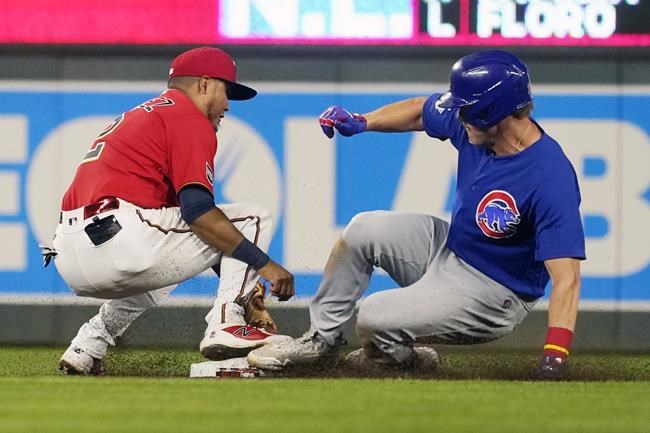Chicago Cubs' Patrick Wisdom, right, beats the tag by Minnesota Twins second baseman Luis Arraez to double in the seventh inning of a baseball game, Tuesday, Aug. 31, 2021, in Minneapolis. (AP Photo/Jim Mone)
