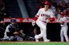 Los Angeles Angels designated hitter Shohei Ohtani, right, yells after hitting a foul ball into the New York Yankees' dugout, as Yankees catcher Gary Sanchez watche during the fourth inning of a baseball game in Anaheim, Calif., Tuesday, Aug. 31, 2021. (AP Photo/Alex Gallardo)