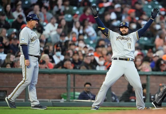 Milwaukee Brewers' Rowdy Tellez (11) celebrates after hitting a triple to drive in a run against the San Francisco Giants as third base coach Jason Lane, left, looks on during the third inning of a baseball game Tuesday, Aug. 31, 2021, in San Francisco. (AP Photo/Tony Avelar)