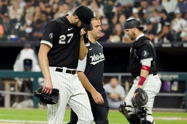 Chicago White Sox head trainer James Kruk, center, walks with starting pitcher Lucas Giolito to the clubhouse as catcher Yasmani Grandal, right, heads to the mound during the fifth inning of a baseball game against the Pittsburgh Pirates Tuesday, Aug. 31, 2021, in Chicago. (AP Photo/Charles Rex Arbogast)