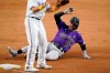Texas Rangers' Charlie Culberson stands by the bag as Colorado Rockies' Trevor Story (27) reaches third on a Rangers' error in the ninth inning of a baseball game in Arlington, Texas, Wednesday, Sept. 1, 2021. The Rockies' Charlie Blackmon scored on the play. (AP Photo/Tony Gutierrez)