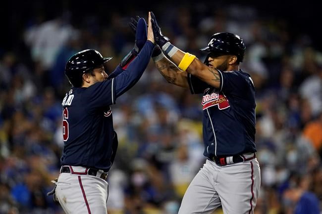 Atlanta Braves' Eddie Rosario, right, is high-fived at home plate by Travis d'Arnaud after Rosario's two-run home run against the Los Angeles Dodgers during the seventh inning of a baseball game Wednesday, Sept. 1, 2021, in Los Angeles. (AP Photo/Marcio Jose Sanchez)