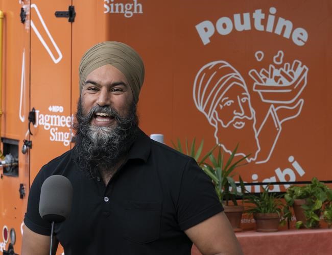 New Democratic leader Jagmeet Singh laughs after holding a campaign stop in front of the Punjabi Poutine food truck , Thursday, September 2, 2021 in Montreal. THE CANADIAN PRESS/Adrian Wyld