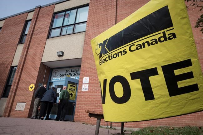 Voters enter the polling station at St. Luigi Catholic School during election day in Toronto on Monday, October 21, 2019. Elections Canada says it still has