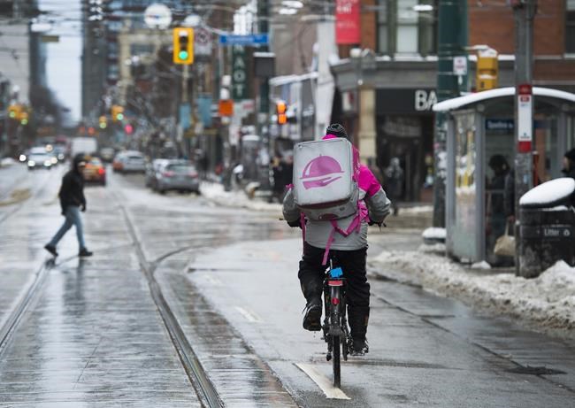 A Foodora courier is pictured as they pick up an order for delivery from a restaurant in Toronto, Thursday, Feb. 27, 2020. THE CANADIAN PRESS/Nathan Denette