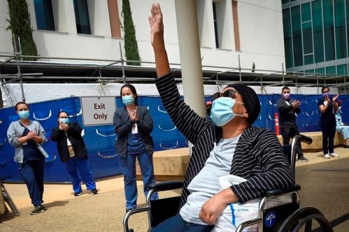 FILE - In this May 19, 2020, file photo, Karen Parker-Bryant, 64, raises a hand skyward after she was released from Clovis Community Hospital after a battle with COVID-19, in Fresno, Calif. Hospitals in the heart of California’s Central Valley are running out of beds in their intensive care units because of an influx of coronavirus patients, prompting officials on Friday, Sept. 3, 2021, to declare an official “surge.