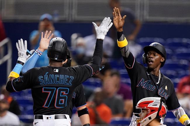 Miami Marlins' Jesus Sanchez (76) is congratulated by Jazz Chisholm Jr., right, and Miguel Rojas, left rear, after Sanchez hit a home run scoring the three during the first inning against the Philadelphia Phillies in a baseball game Friday, Sept. 3, 2021, in Miami. (AP Photo/Wilfredo Lee)