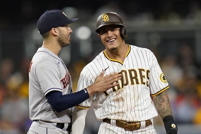 Houston Astros shortstop Carlos Correa, left, jokes with San Diego Padres' Manny Machado, who stands on second base during the seventh inning of a baseball game Friday, Sept. 3, 2021, in San Diego. (AP Photo/Gregory Bull)