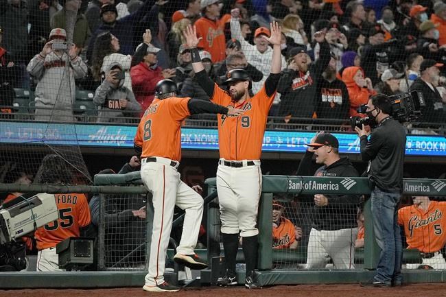San Francisco Giants' Brandon Belt (9) celebrates with third base coach Ron Wotus (8) after the replay showed that Buster Posey was safe at first base for a 3-2 victory against the Los Angeles Dodgers Friday, Sept. 3, 2021, in San Francisco. (AP Photo/Tony Avelar)