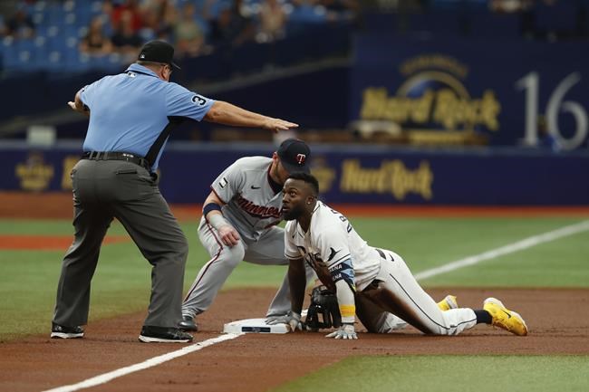 Tampa Bay Rays' Randy Arozarena, right, beats the throw to Minnesota Twins third baseman Josh Donaldson, center, during the first inning of a baseball game on Saturday, Sept. 4, 2021, in St. Petersburg, Fla. (AP Photo/Scott Audette)