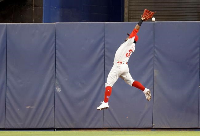 Philadelphia Phillies center fielder Odubel Herrera can't catch a fly ball hit by Miami Marlins' Miguel Rojas during the first inning of a baseball game Saturday, Sept. 4, 2021, in Miami. (AP Photo/Rhona Wise)