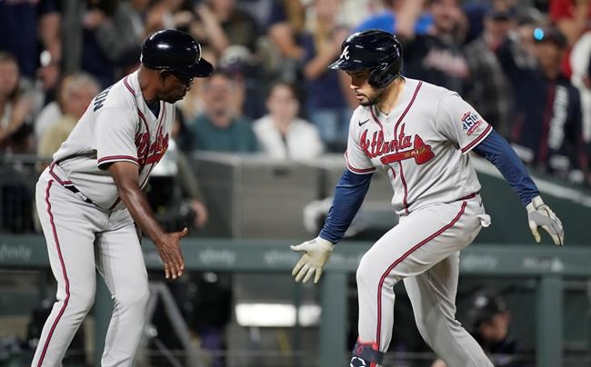 Atlanta Braves third base coach Ron Washington, left, congratulates pinch hitter Travis d'Arnaud as d'Arnaud circles the bases after hitting a solo home run off Colorado Rockies relief pitcher Carlos Estevez in the ninth inning of a baseball game Saturday, Sept. 4, 2021, in Denver. (AP Photo/David Zalubowski)