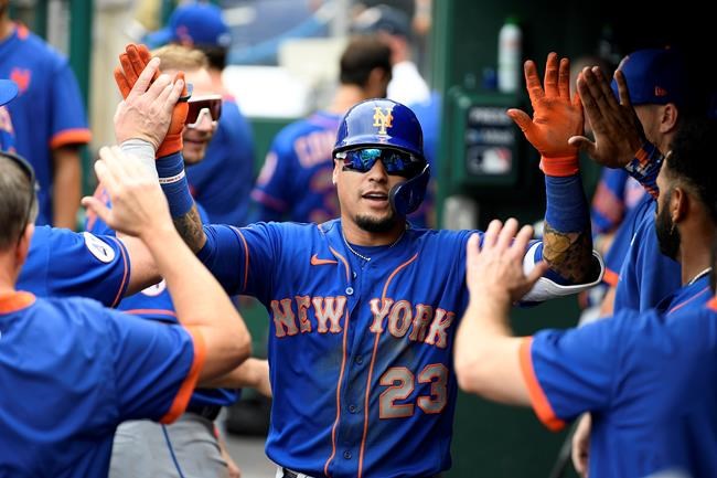 New York Mets' Javier Baez celebrates his home run in the dugout during the third inning of a baseball game against the Washington Nationals, Sunday, Sept. 5, 2021, in Washington. (AP Photo/Nick Wass)