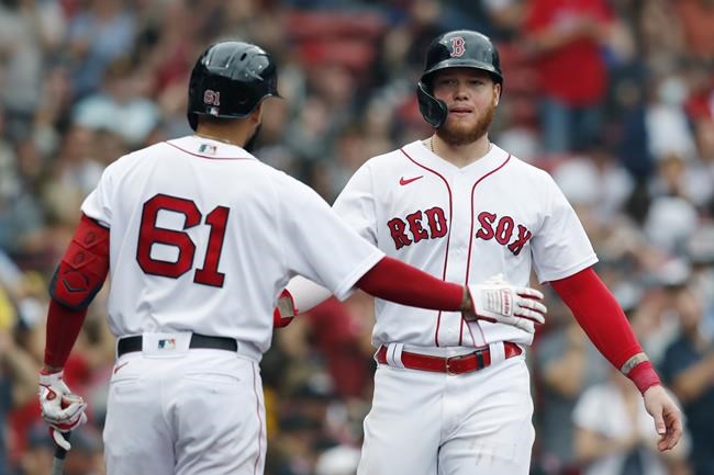 Boston Red Sox's Alex Verdugo celebrates with Jack Lopez (61) after scoring on a double by Travis Shaw during the fifth inning of a baseball game against the Cleveland Indians, Sunday, Sept. 5, 2021, in Boston. (AP Photo/Michael Dwyer)