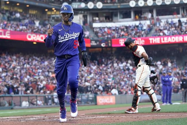 Los Angeles Dodgers' Mookie Betts, left, scores in front of San Francisco Giants catcher Curt Casali after pitcher Camilo Doval walked Will Smith with the bases during the fifth inning of a baseball game in San Francisco, Sunday, Sept. 5, 2021. (AP Photo/Jeff Chiu)