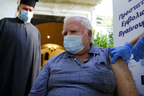 Michalis Vardakis, 73, receives a dose of the Johnson and Johnson COVID-19 vaccine, outside the church of the Virgin Mary, during a vaccination roll out, in the town of Archanes, on the island of Crete, Greece, Monday, Sept. 6, 2021. Greece has begun administering vaccinations for COVID-19 outside churches. It's a pilot program that was recently announced by the government as a means of encouraging more people to get the shots. Mobile National Health Organization units began administering shots Monday in a church yard in the town of Archanes near the city of Heraklion on the southern island of Crete. (AP Photo/Michael Varaklas)