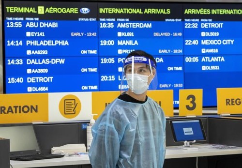 A worker waits for arrivals at the COVID-19 testing centre in Terminal 3 at Pearson Airport in Toronto, Wednesday, Feb. 3, 2021. The federal government has added fully vaccinated foreign nationals to the ranks of travellers who are once again welcome on Canadian soil. THE CANADIAN PRESS/Frank Gunn