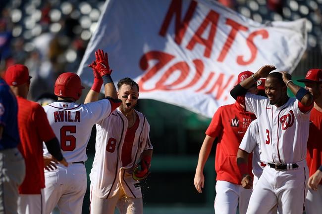 Washington Nationals' Carter Kieboom (8) high-fives Alex Avila (6) after hitting a walkoff single to drive in Josh Bell during the ninth inning of a baseball game against the New York Mets, Monday, Sept. 6, 2021, in Washington. Nationals' Alcides Escobar, right, looks on. (AP Photo/Nick Wass)