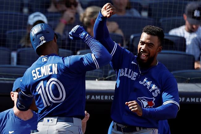 Toronto Blue Jays' Teoscar Hernandez congratulates Marcus Semien (10) on his grand slam against the New York Yankees during the ninth inning of a baseball game on Monday, Sept. 6, 2021, in New York. (AP Photo/Adam Hunger)