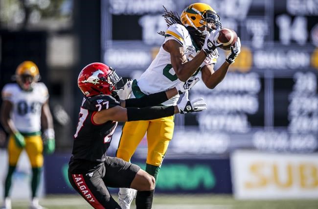 Edmonton Elks' Derel Walker, right, brings down a pass as Calgary Stampeders' Jonathan Moxey grabs him during second half CFL football action in Calgary, Monday, Sept. 6, 2021.THE CANADIAN PRESS/Jeff McIntosh