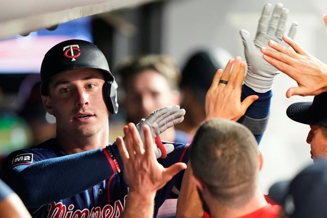 Minnesota Twins' Brent Rooker celebrates with teammates after Rooker hit a solo home run during the seventh inning of the team's baseball game against the Cleveland Indians, Tuesday, Sept. 7, 2021, in Cleveland. (AP Photo/Tony Dejak)