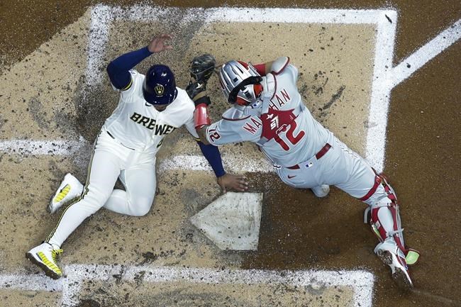 Milwaukee Brewers' Eduardo Escobar scores safely past Philadelphia Phillies catcher Rafael Marchan during the third inning of a baseball game Tuesday, Sept. 7, 2021, in Milwaukee. Escobar scored from second on a hit by Christian Yelich. (AP Photo/Morry Gash)