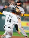 San Francisco Giants shortstop Brandon Crawford, back, throws to first base after putting out Colorado Rockies' Rio Ruiz at second base on the front end of a double play hit into by Raimel Tapia to end the fifth inning of a baseball game Tuesday, Sept. 7, 2021, in Denver. (AP Photo/David Zalubowski)