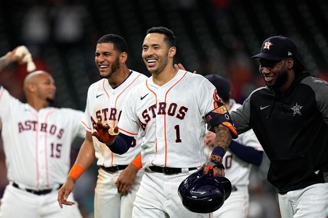 Houston Astros' Carlos Correa (1) celebrates with teammates after hitting a game-winning RBI ground-rule double against the Seattle Mariners during the 10th inning of a baseball game Tuesday, Sept. 7, 2021, in Houston. The Astros won 5-4 in 10 innings. (AP Photo/David J. Phillip)