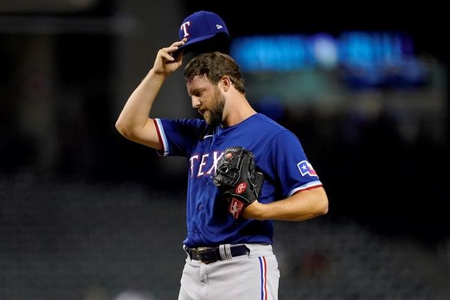 Texas Rangers' Jordan Lyles adjusts his cap after giving up a run to the Arizona Diamondbacks during the third inning of a baseball game, Tuesday, Sept. 7, 2021, in Phoenix. (AP Photo/Matt York)