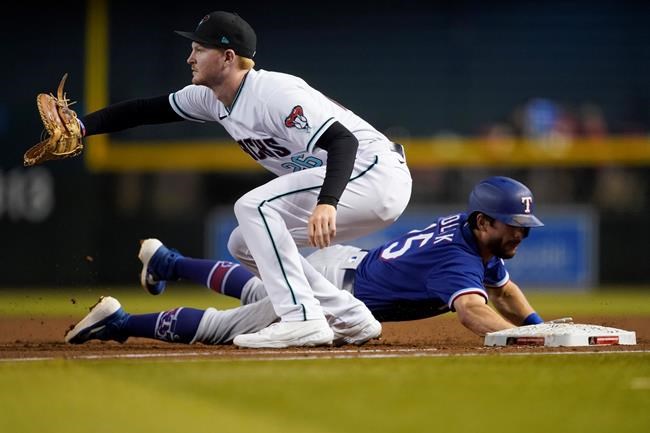 Texas Rangers' Nick Solak dives back safely on a pick-off attempt as Arizona Diamondbacks' Pavin Smith, left, makes the catch during the first inning of a baseball game, Tuesday, Sept. 7, 2021, in Phoenix. (AP Photo/Matt York)