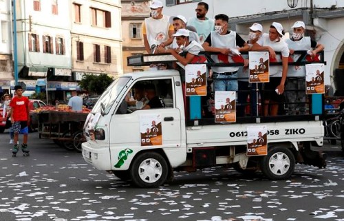 Supporters of the Constitutional Union look out from a truck during a campaign tour in Casablanca, Morocco, Monday, Sept. 6, 2021. Voting booths open on Sept. 8 for the North African kingdom's parliamentary elections, in which 395 seats in the upper house of Parliament are up for grabs. Communal and regional elections take place on the same day. (AP Photo/Abdeljalil Bounhar)