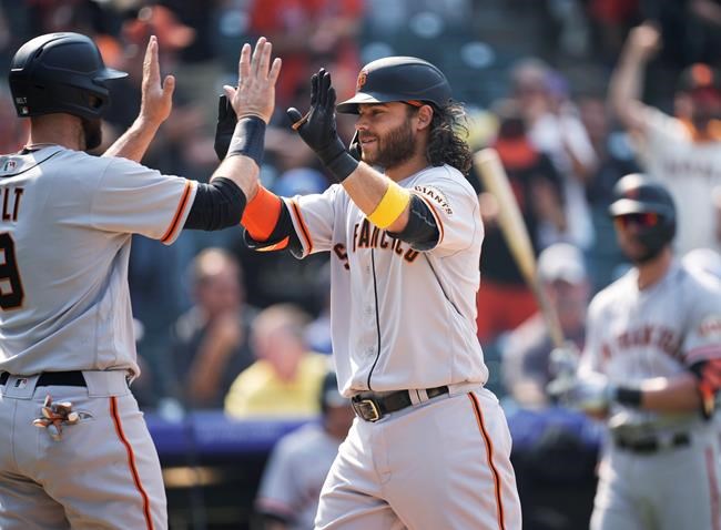 San Francisco Giants' Brandon Belt, left, congratulates Brandon Crawford, who crosses home plate after hitting a three-run home run off Colorado Rockies starting pitcher Jon Gray during the sixth inning of a baseball game Wednesday, Sept. 8, 2021, in Denver. (AP Photo/David Zalubowski)
