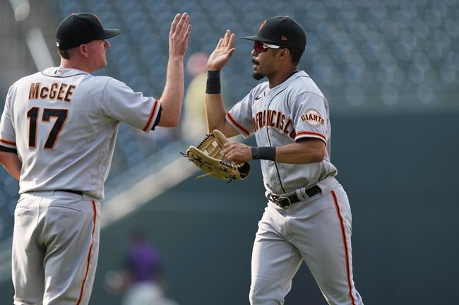 San Francisco Giants relief pitcher Jake McGee, left, congratuates right fielder LaMonte Wade Jr. after the team's baseball game against the Colorado Rockies on Wednesday, Sept. 8, 2021, in Denver. The Giants won 7-4. (AP Photo/David Zalubowski)