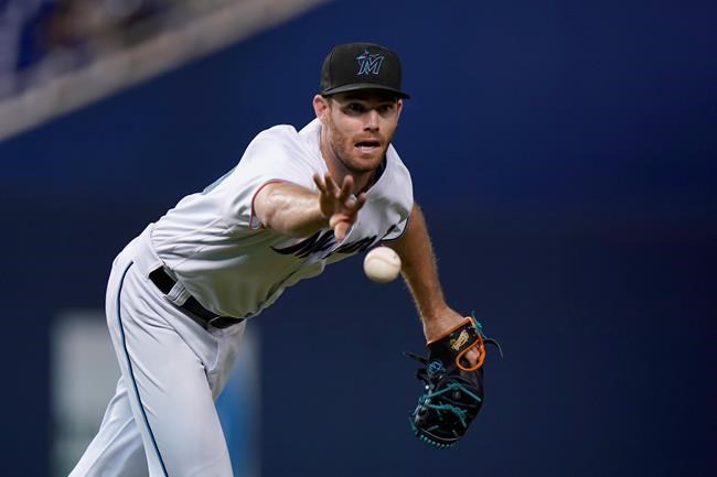 Miami Marlins relief pitcher Anthony Bender tosses the ball to first for the out on New York Mets' Jeff McNeil during the 10th inning of a baseball game Wednesday, Sept. 8, 2021, in Miami. (AP Photo/Wilfredo Lee)