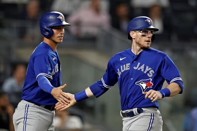 Toronto Blue Jays' Danny Jansen, right, and Jake Lamb celebrate after scoring on a hit by Marcus Semien against the New York Yankees during the fourth inning of a baseball game Wednesday, Sept. 8, 2021, in New York. (AP Photo/Adam Hunger)