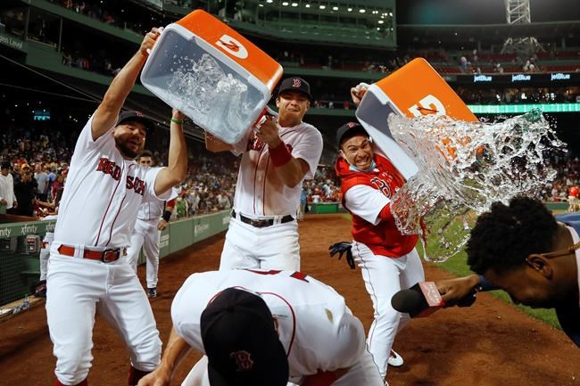 Boston Red Sox's Kyle Schwarber, Bobby Dalbec and Christian Vazquez, from left, dump water onto teammate Hunter Renfroe after the team's 2-1 win over the Tampa Bay Rays in a baseball game Wednesday, Sept. 8, 2021, at Fenway Park in Boston. (AP Photo/Winslow Townson)