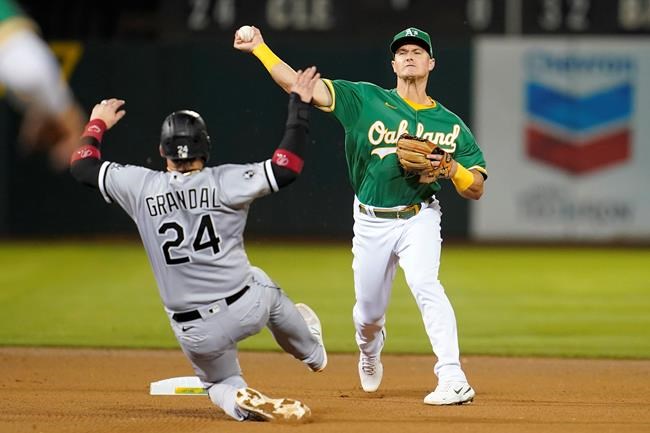 Oakland Athletics' Matt Chapman, right, throws to first base after forcing Chicago White Sox's Yasmani Grandal (24) out at second base on a double play hit into by Gavin Sheets during the fourth inning of a baseball game in Oakland, Calif., Wednesday, Sept. 8, 2021. (AP Photo/Jeff Chiu)
