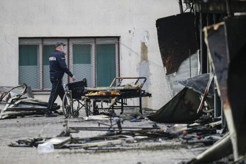 A police officer walks past burned hospital equipment on the site of a destroyed field hospital following a fire in North Macedonia's northwestern city of Tetovo, early Thursday, Sept. 9, 2021. The government of North Macedonia will hold an emergency meeting Thursday over a fire overnight that ripped through a field hospital set up to treat COVID-19 patients, leaving numerous people dead. (AP Photo/Visar Kryeziu)