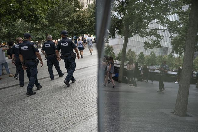 NYPD officer Michael Dougherty, a 25-year veteran, patrols with his colleagues at the National September 11 Memorial & Museum where names of his deceased colleagues and friends are displayed, Monday, Aug. 16, 2021, in New York.