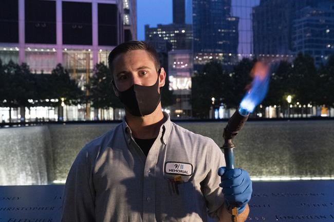 Kevin Hansen, an engineer at the September 11 Memorial, poses with a torch he uses to clean and burnish the names cut into the metal plates that border the south pool, Wednesday, Aug. 4, 2021, in New York. Hansen says of the work he does,