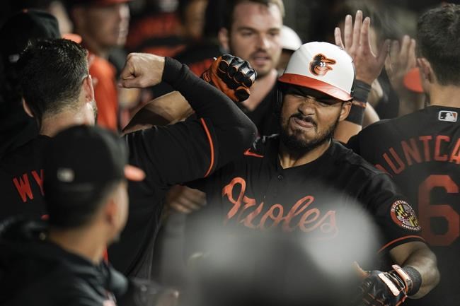 Baltimore Orioles' Anthony Santander, center, is greeted in the dugout by teammates after hitting a three-run home run off Toronto Blue Jays starting pitcher Julian Merryweather during the seventh inning of a baseball game, Friday, Sept. 10, 2021, in Baltimore. (AP Photo/Julio Cortez)