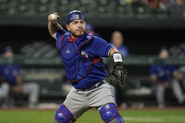 Toronto Blue Jays catcher Alejandro Kirk throws to first while putting out Baltimore Orioles' Ryan Mountcastle on a dribbler in front of the plate during the seventh inning of a baseball game, Friday, Sept. 10, 2021, in Baltimore. (AP Photo/Julio Cortez)